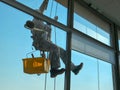 Industrial mountaineering, a man restores joints in windows and washes them Royalty Free Stock Photo