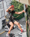 Industrial mountaineering worker cleaning window outside building. Royalty Free Stock Photo