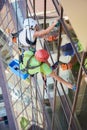 Industrial mountaineering worker cleaning window outside building. Royalty Free Stock Photo