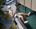 Industrial mountaineering worker cleaning window outside building. Royalty Free Stock Photo