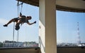 Industrial mountaineering worker cleaning window outside building. Royalty Free Stock Photo