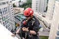 Industrial mountaineering worker hangs over residential facade