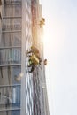 Group Industrial mountaineering workers in uniform washing exterior building glazing