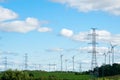 An industrial nature landscape with many high voltage power lines pylons and wind generators Royalty Free Stock Photo