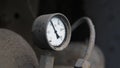 Industrial old white vintage barometer with old dirty gas cylinder.