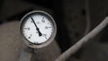 Industrial old white vintage barometer with old dirty gas cylinder.