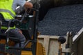 Industrial pavement machine laying fresh asphalt on road construction.