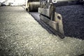 Industrial pavement truck laying fresh asphalt, bitumen during road works. Construction of highways