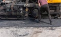 Industrial pavement truck laying fresh asphalt on construction site