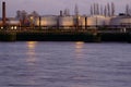 Industrial petrol tanks by the river Royalty Free Stock Photo