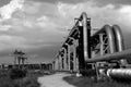 Industrial pipelines on pipe-bridge against sky bw Royalty Free Stock Photo