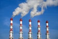 Industrial pipes with white smoke over blue sky. Horizontal photo Royalty Free Stock Photo