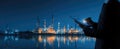 Industrial plant at night with person using tablet reflecting in water Royalty Free Stock Photo
