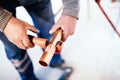 Industrial Plumber cutting a copper pipe with a pipe cutter.