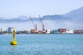 Industrial port blue water clear weather white fog on the backgroundyellow lighthouse landscape