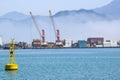 Industrial port blue water clear weather white fog on the backgroundyellow lighthouse landscape