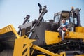 Industrial portrait of working man, excavator driver climbs into cab to perform work on construction site Royalty Free Stock Photo