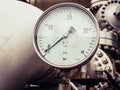 Industrial pressure gauge  in bar on a line of large metal pipes Royalty Free Stock Photo