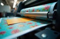 Industrial printing machine processes colorful paper sheets with floral patterns. Variable data printing tech prepares