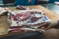 Industrial processing of meat. A man cook cuts a piece of tenderloin in a butcher& x27;s shop Royalty Free Stock Photo