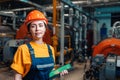 Industrial production concept. Portrait of a female engineer in uniform and helmet with a tablet in her hand. In the background-