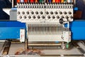 Industrial programmable embroidery machine with multicolored threads at work. Closeup. Copy space