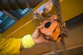 Industrial rope access inspector worker rigger hand commencing safety daily inspection check on lifting hoist chain block