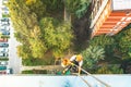 Industrial rope access worker hanging from the building while painting the exterior facade wall. Industrial alpinism concept image