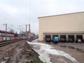 Industrial scene featuring a railway track, loading docks, and an overcast sky. Royalty Free Stock Photo