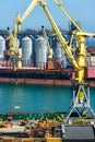 Industrial seaport infrastructure, sea, cranes and dry cargo ship, grain silo, bulk carrier vessel and grain storage elevators, Royalty Free Stock Photo