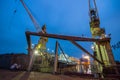 Industrial ship repair yard at night, floating dock lit up, vessel maintenance underway. Urban maritime scene with heavy