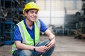 Industrial smiling worker wearing helmet holding radio walkie talkie at manufacturing plant factory industry, Asian young male Royalty Free Stock Photo