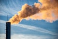 Industrial smoke from chimney on blue sky.