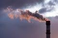 Industrial smoke from chimney on dramatic sundown sky. Factory pipe sending smoke to the atmosphere, air pollution of industry Royalty Free Stock Photo