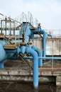 Industrial space with lots of pipes and communications on a background of blue sky. old water treatment plant on the city`s wate Royalty Free Stock Photo