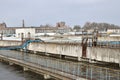 Industrial space with lots of pipes and communications on a background of blue sky. old water treatment plant on the city`s water Royalty Free Stock Photo