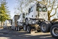 Industrial standard big rig semi truck tractor towing another three semi truck tractors on a fifth wheel hitch with the front axle Royalty Free Stock Photo