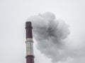 Industrial structure with big pipe of brown brick under gray sky. Royalty Free Stock Photo