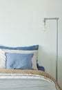 Industrial style reading lamp next to bed in blue and gray color scheme
