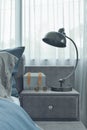 Industrial style reading lamp next to blue color scheme bedding