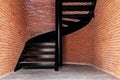 Industrial style spiral staircase with red brick wall and concrete floor