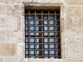 Industrial style window with reflections, Stoneframed window featuring reflective glass and iron bars Royalty Free Stock Photo