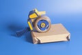 Industrial tape dispenser on a cardboard box Royalty Free Stock Photo