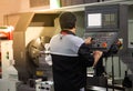 Industrial technician operating CNC lathing machine