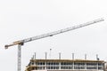 Industrial tower crane builds new concrete city building or apartments on construction site Royalty Free Stock Photo