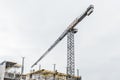 Industrial tower crane builds new concrete city building or apartments on construction site Royalty Free Stock Photo