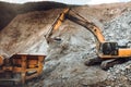 Industrial track type excavator digging and loading rock crusher