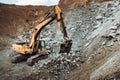 Industrial track type excavator digging at a quarry or a construction site