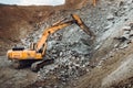 Industrial track type excavator digging at a quarry or a construction site