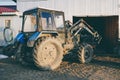 Industrial tractor close-up. Blue tractor with huge wheels. A blue tractor stands at the garage for repairs